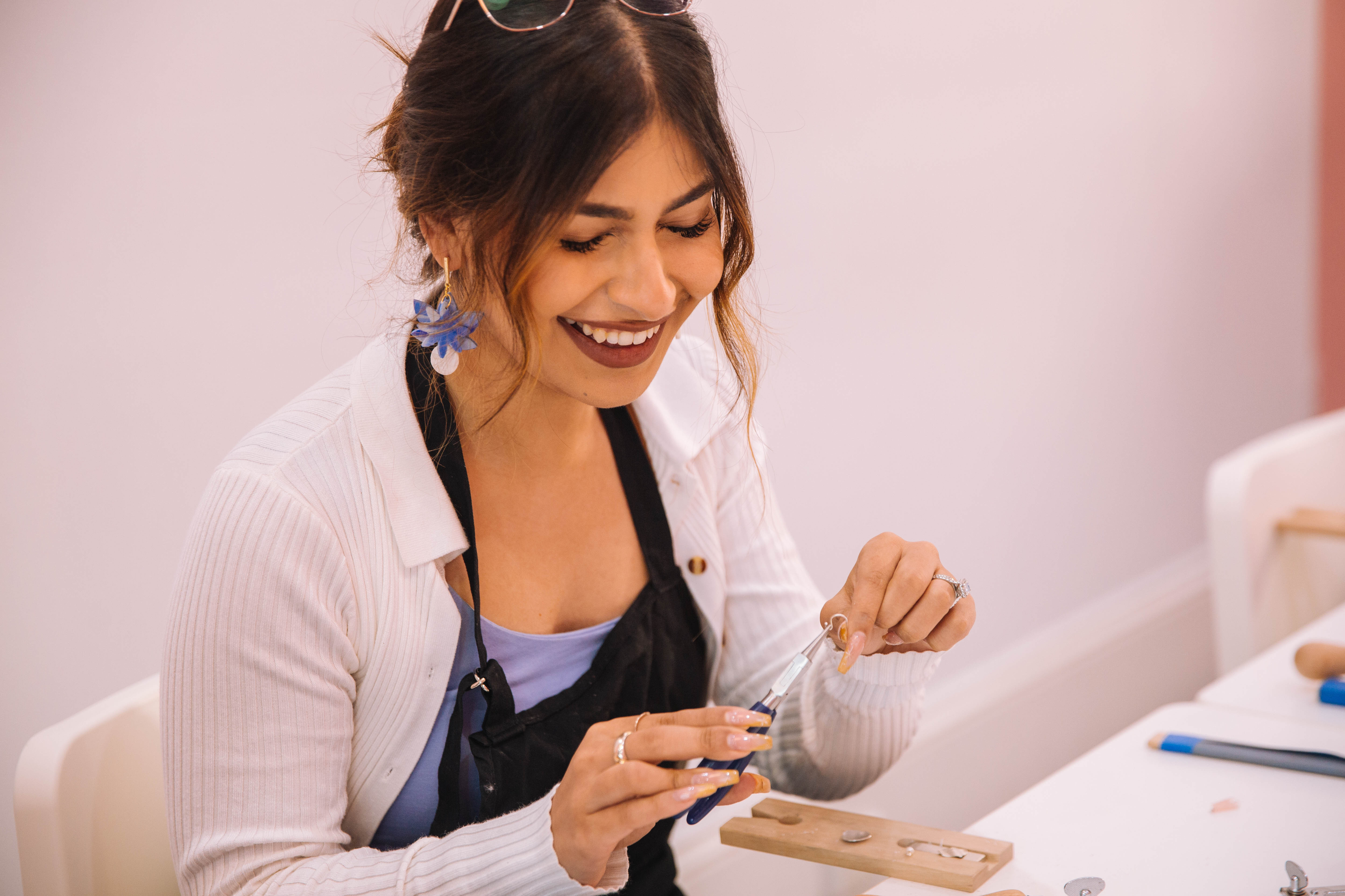 A woman smiling as she makes her own ring